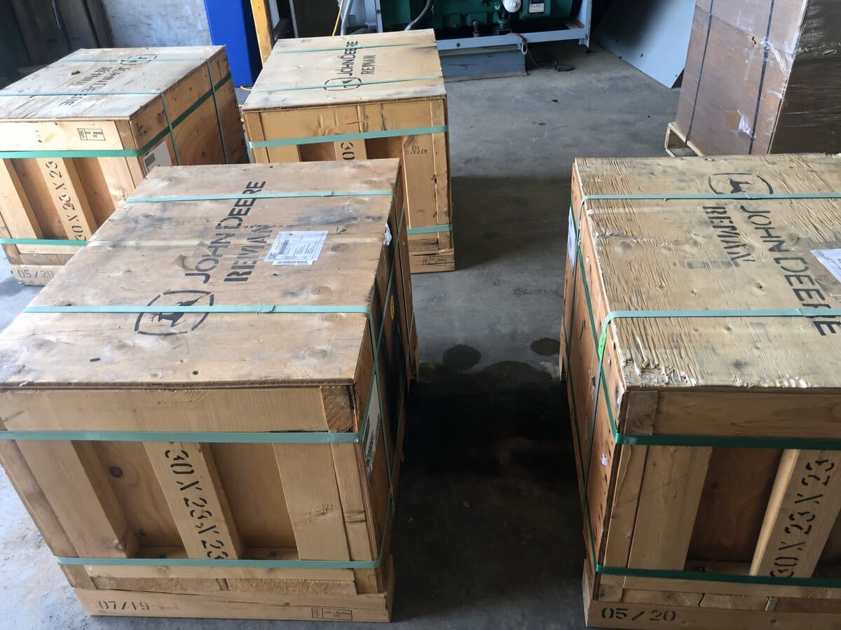 Rows of matching John Deere Reman wooden crates on a warehouse floor
